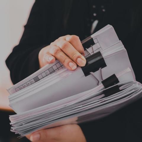 Mujer sosteniendo una pila de documentos